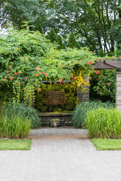 istock Landscape architecture featuring pergola and brass water feature and perennials 1606050155