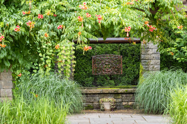 istock Landscape architecture featuring pergola and brass water feature and perennials 1606050684