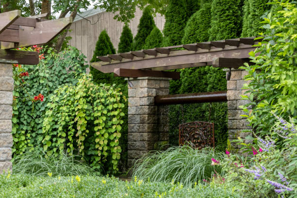 istock Landscape architecture featuring pergola and brass water feature and perennials 1606050691