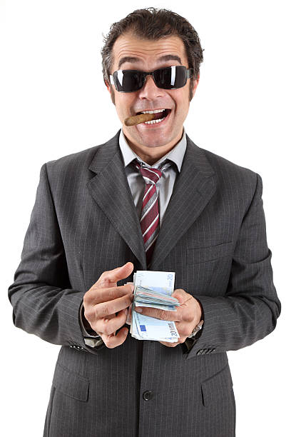 Happy gangster Mature male with cigar in his mouth counts money, isolated on white background mafia boss stock pictures, royalty-free photos & images