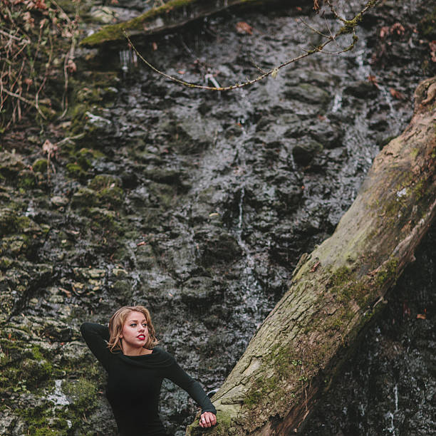 Joven hermosa mujer sentada en un árbol - foto de stock