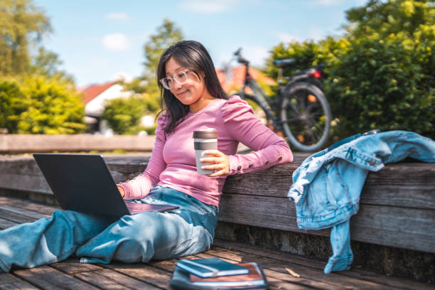 istock Smiling Young Female Asian Student Studying on Bench 1606135319