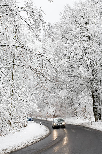 道路を車冬の森 hoar フロスト - car winter road reflector snow ストックフォトと画像