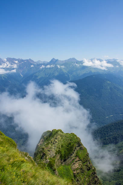 istock landscape - white clouds on mountain tops against a blue sky 1606183659
