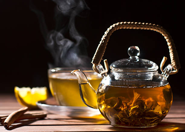 istock Glass teapot filled with tea sitting on a table with a cup 160621372