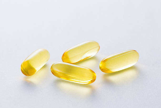 Yellow capsule Cod liver oil omega 3 capsules. cod liver oil fish oil vitamin a pill stock pictures, royalty-free photos & images