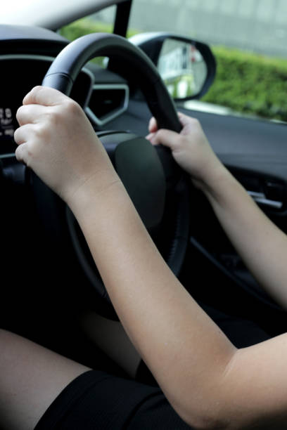 istock Hands holding steering wheel of car 1606259943