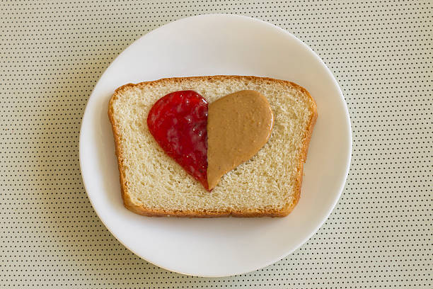 Peanut butter and jelly in the shape of a heart on a homemade slice of bread.