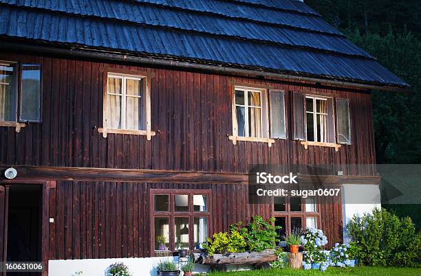 Photo libre de droit de Alpine Lodge Avec Des Fleurs En Pots Sur La Pelouse banque d'images et plus d'images libres de droit de Alpes européennes