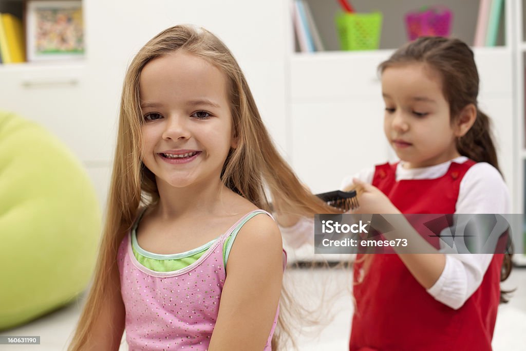 Combing hair Little girl having her daily beauty routine - combing hair Beautiful People Stock Photo