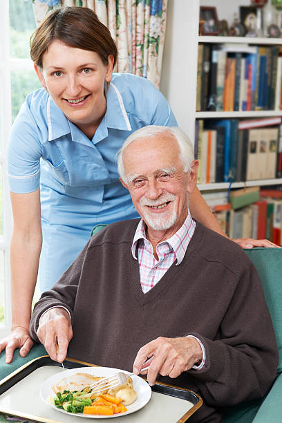 istock Female caretaker serving lunch to a senior man 160632192