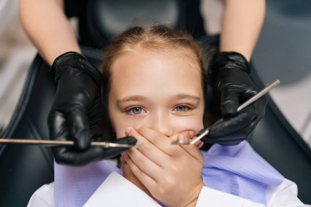 portrait en gros plan d’une petite fille mignonne fermant la bouche par peur dans une clinique dentaire, effrayée par la perceuse dentaire, effrayée par le traitement. - dental hygiene dental equipment dental drill practicing photos et images de collection