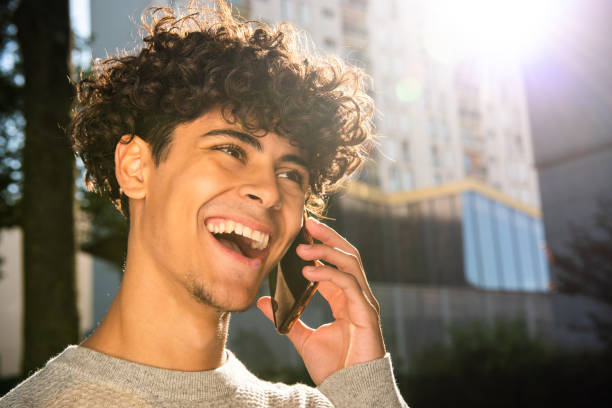 istock Close up happy young arab man talking with mobile phone outside 1606330885