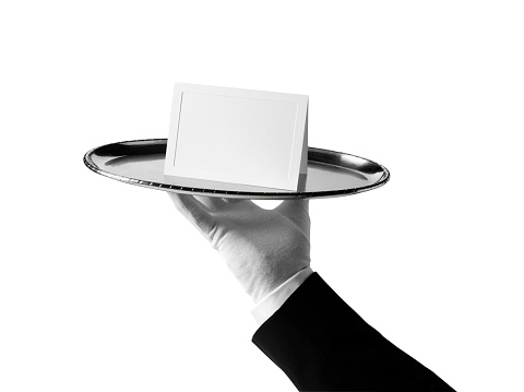 First class service. Waiter holding blank card on a silver tray. Isolated on white with clipping path