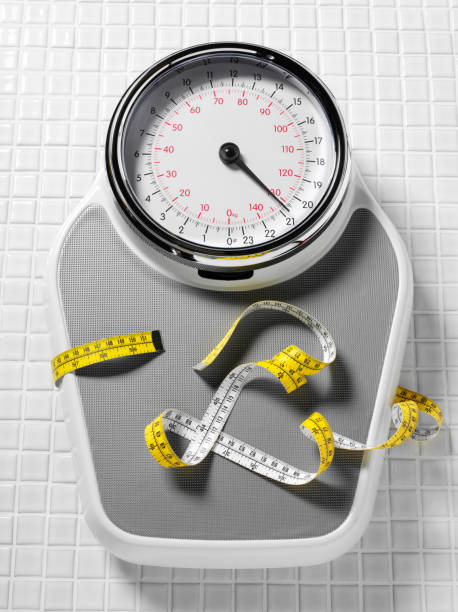 istock Bathroom Scales Wrapped in a Tape Measure 160637089