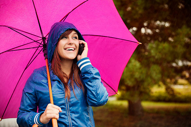 istock Young woman with mobile phone on rainy day 160639247