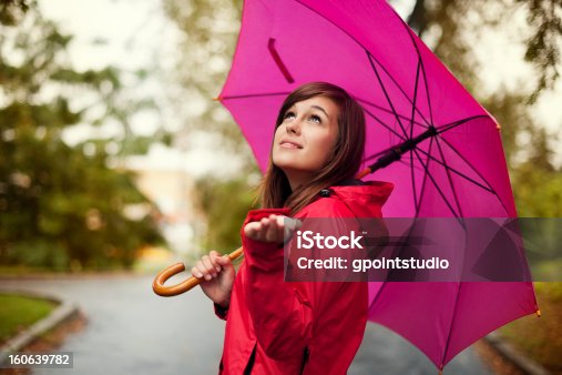 istock Beautiful woman with umbrella checking for rain 160639782