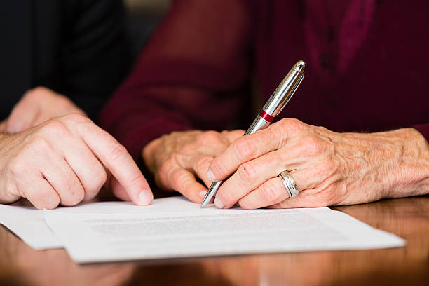 Senior Contract A senior citizen signing a document. will legal document photos stock pictures, royalty-free photos & images