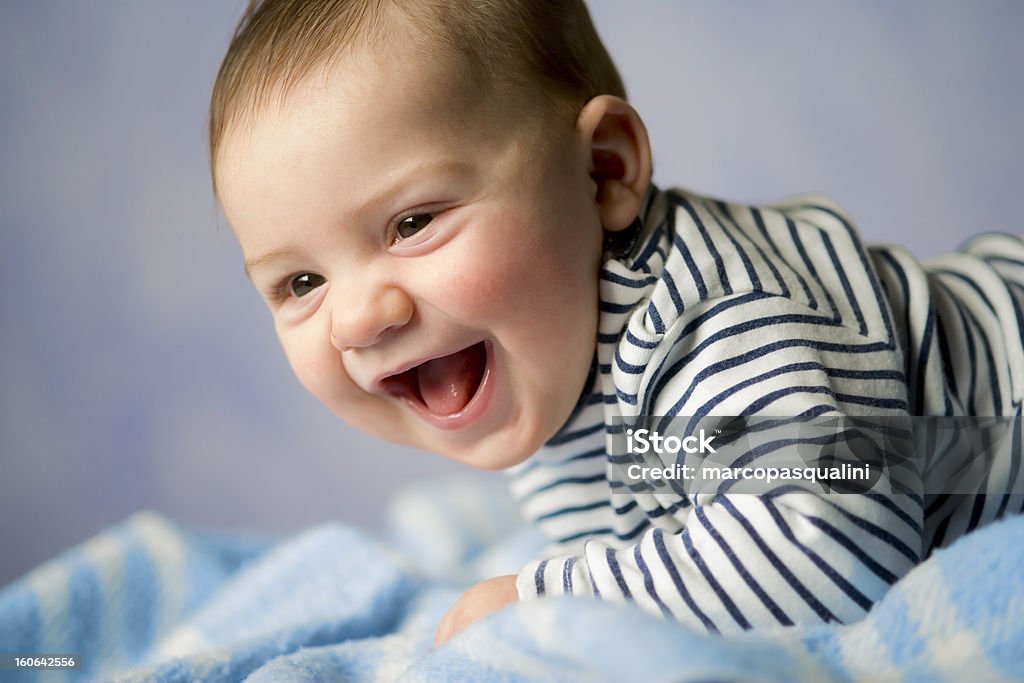 Happy baby Smiling baby, wearing striped shirt, lying on blanket. 0-11 Months Stock Photo