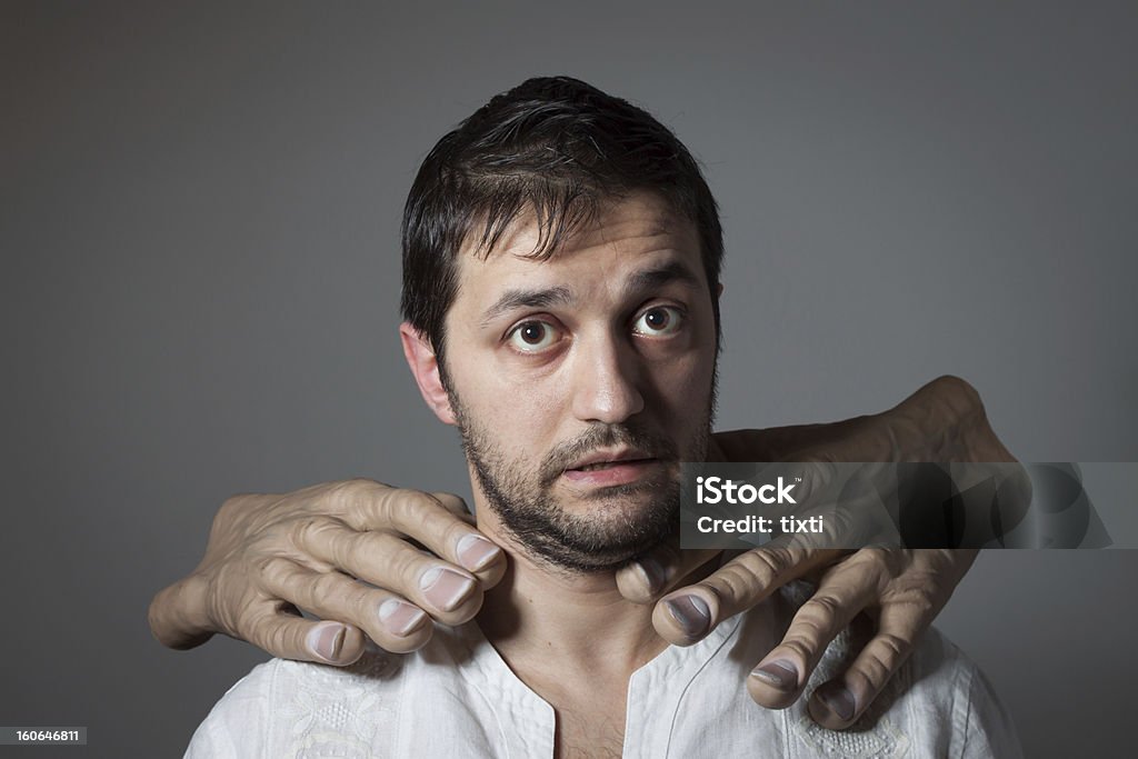 Junger bärtiger Mann choked von zwei riesigen Hände - Lizenzfrei Groß Stock-Foto