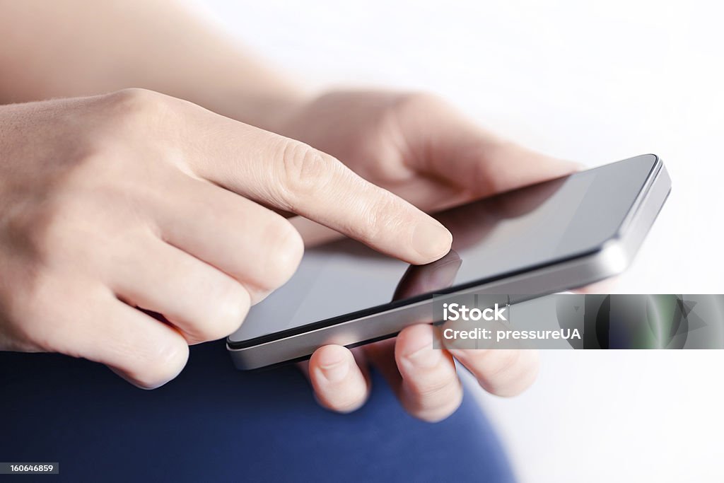 Girl With Mobile Smart Phone Girl hand touching screen on modern mobile smart phone. Close-up image with shallow depth of field focus on finger. Adult Stock Photo