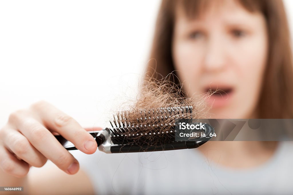 Utrata włosów grzebieniem w ręce kobiety - Zbiór zdjęć royalty-free (Kobiety)