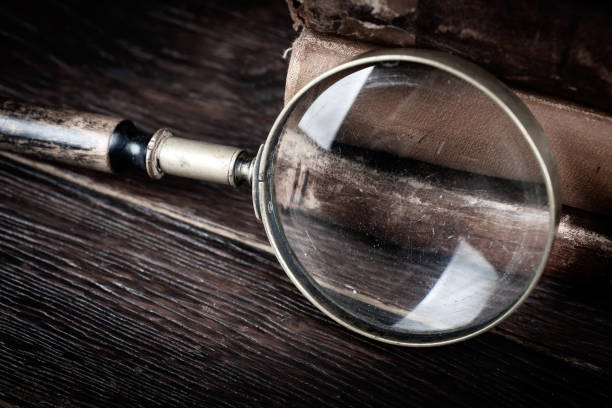 istock Old vintage magnifying glass with books on table 1606549123