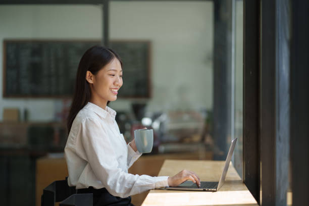 istock Young adorable Asian office worker working with laptop computer, sitting in her office room. 1606576292