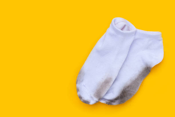 istock Dirty white socks on yellow background. 1606596968