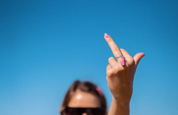 Middle finger gesture. Heart shaped ring on female middle finger. Fuck you concept. Middle finger gesture. Heart shaped ring on female middle finger. Fuck you concept. middle finger emoji stock pictures, royalty-free photos & images