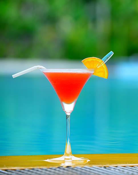 Cocktail at edge of the swimming pool stock photo