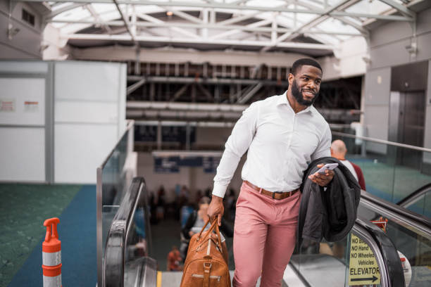 Man smiles, riding escalator in an airport
