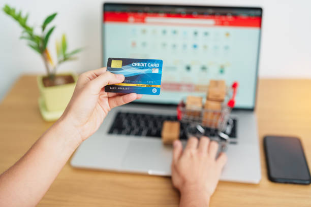 woman hand holding credit card and using laptop with mobile phone for online shopping while making order. Marketplace platform website, technology, ecommerce, shipping delivery and online payment mujer sosteniendo la tarjeta de crédito y usando una computadora portátil con un teléfono móvil para compras en línea mientras hace el pedido. sitio web de la plataforma de mercado, tecnología, comercio electrónico, entrega de envíos y pago en lín