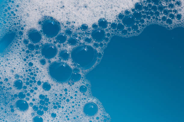 istock Detergent foam bubble on water. Blue background, Soap sud 1606736315