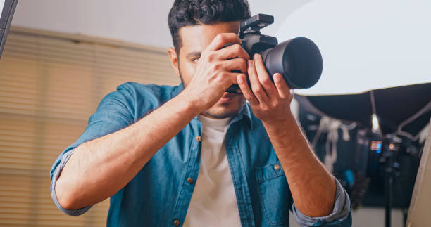 istock Professional male photographer working in studio. 1606757488