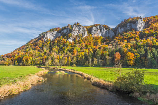 View over the Danube to the Hausener Zinnen in the autumnal Upper Danube Valley, Swabian Alb, Baden-Wuerttemberg, Germany The Danube and rocks Hausener Zinnen in the autumnal Danube valley, Hausen im Tal, Upper Danube Valley, Swabian Alb, Baden-Wuerttemberg, Germany danube valley stock pictures, royalty-free photos & images