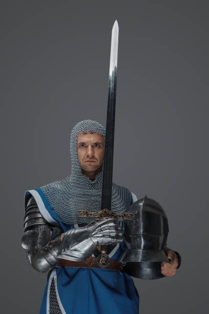 istock Proud knight stands holding his sword and helmet 1606832591