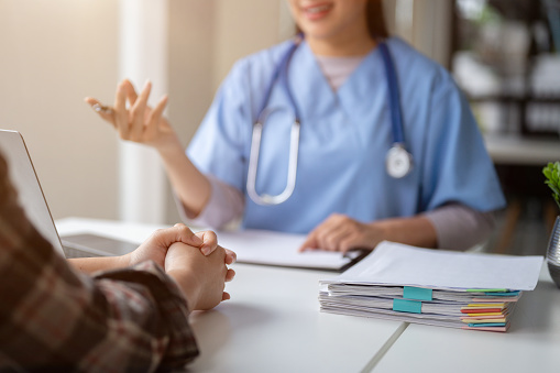 Close-up hand image of a serious patient having a medical consultation with a professional doctor at a hospital. Medical checkup, counseling, and diagnosis of disease