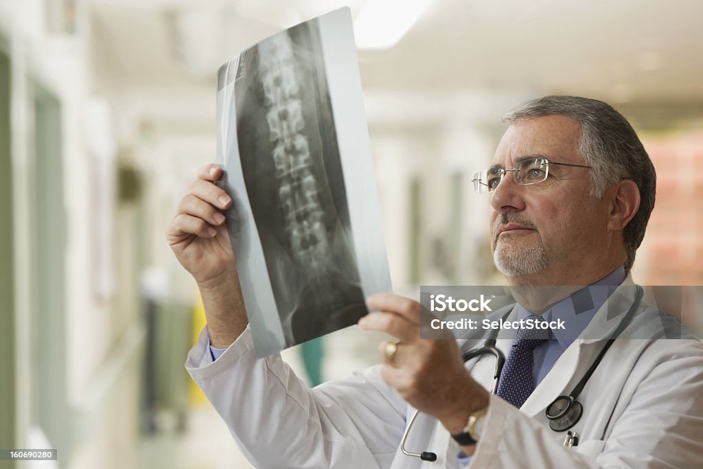 Starsze lekarz Patrząc na zdjęcia rentgenowskie - Zbiór zdjęć royalty-free (Zdjęcie rentgenowskie)