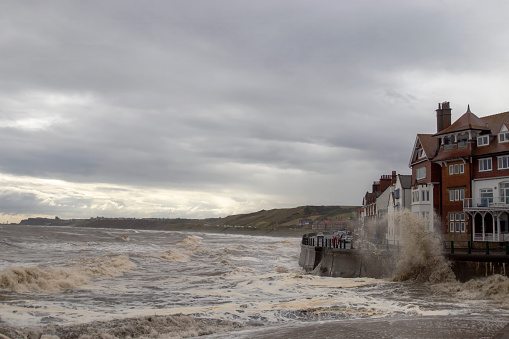 Waves crashing into the sea defences in Sandsend, North Yorkshire, UK
