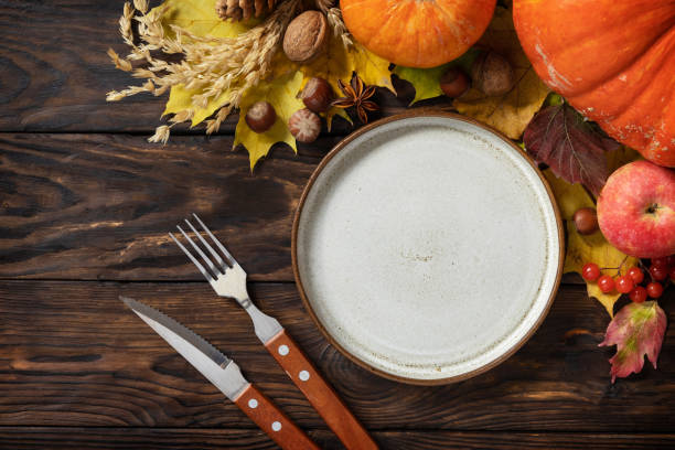 istock Autumn table setting. Autumn Day Thanksgiving or Halloween background. Festive autumn decor from ripe pumpkins, berries and leaves on a wooden background. View from above. Copy space. 1606918792