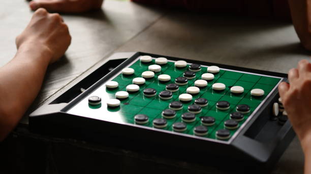 istock Othello or Reversi is a strategy board game for two players, played on an 8×8 uncheckered board. It was invented in 1883. Othello, a variant with a fixed initial setup of the board, was patented in 1971. 1606930708