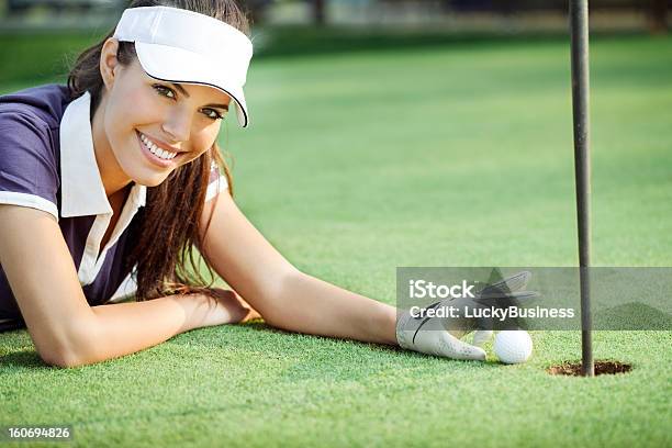 Felice Donna Spingendo Pallina Da Golf Nel Foro - Fotografie stock e altre immagini di Adulto - Adulto, Allegro, Ambientazione esterna