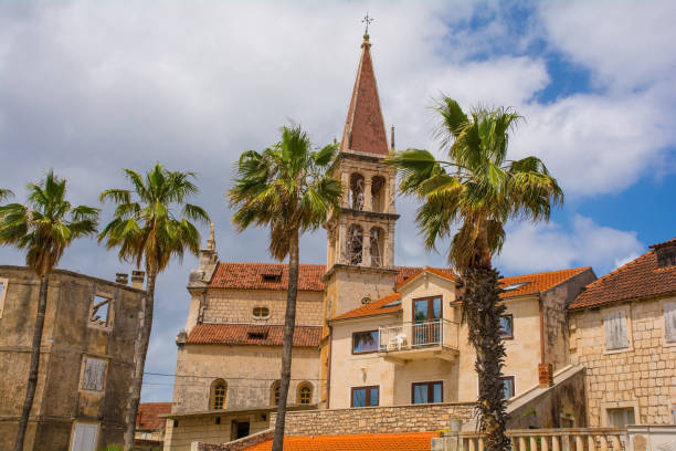 Buildings in Milna, Brac Island, Croatia Historic stone houses on the waterfront of Milna Village on the west coast of Brac Island in Croatia. The bell tower of the Church of Our Lady of the Annunciation is centre old catholic church on island brac croatia stock pictures, royalty-free photos & images