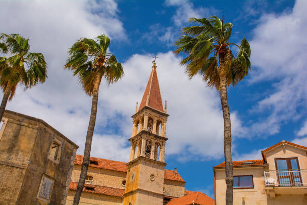 Buildings in Milna, Brac Island, Croatia Historic stone houses on the waterfront of Milna Village on the west coast of Brac Island in Croatia. The bell tower of the Church of Our Lady of the Annunciation is centre old catholic church on island brac croatia stock pictures, royalty-free photos & images