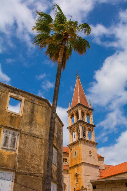 Buildings in Milna, Brac Island, Croatia Historic stone houses on the waterfront of Milna Village on the west coast of Brac Island in Croatia. The bell tower of the Church of Our Lady of the Annunciation is on the right old catholic church on island brac croatia stock pictures, royalty-free photos & images