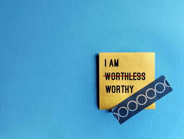 istock Note stick on copy space blue background with text I AM WORTHLESS change to I AM WORTHY, concept of self talk affirmation to overcome low self esteem, to love and accept value of oneself 1607015900