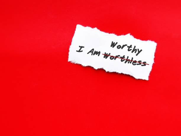 istock Torn white paper on red copy space background with handwritten text I AM WORTHLESS change to I AM WORTHY, concept of self talk affirmation to build self esteem and acceptance 1607024238