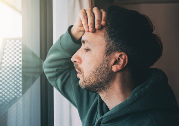 istock Tired man looks at window. Sad Middle-age person in life crisis or problems. Work depression or business bankruptcy concept 1607034444