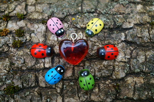Several colorful toy ladybugs and a red heart.